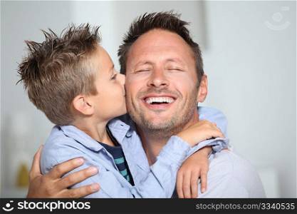 Little bond boy giving a kiss to his dad