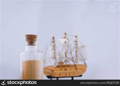Little bottle and a sailboat on a white background