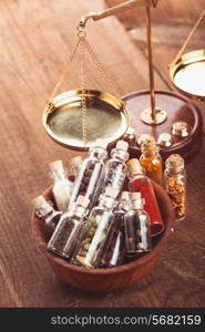 Little bottles with spices in a wooden bowl in the kitchen. Retro decorations