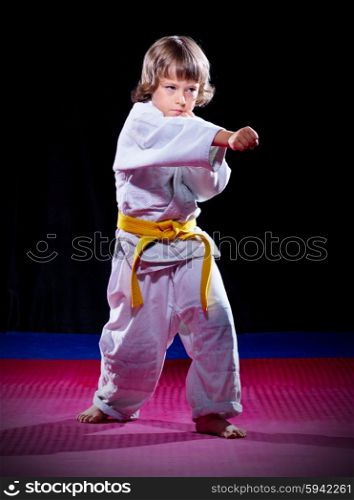 Little boy aikido fighter on black