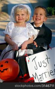 Little Boy And Girl Trick-Or-Treating As A Married Couple