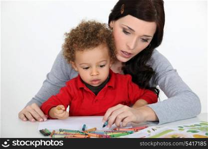 Little boy and mother drawing with crayons