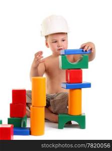 Little boy builds a house of toys on the white background