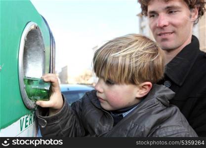 Little boy by recycling bin