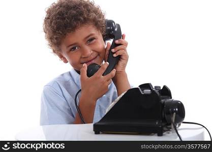 little boy calling with an old telephone