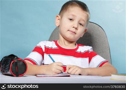 little boy child kid drawing with color pencils on blue background