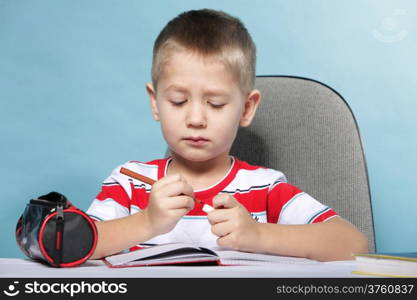 little boy child kid drawing with color pencils on blue background