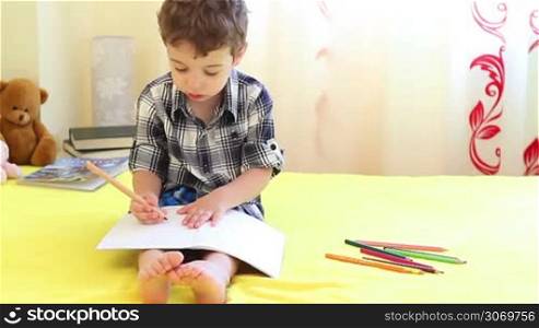 Little boy coloring pictures at home
