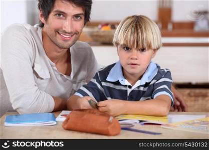 Little boy coloring with his father