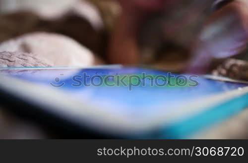 Little boy colouring picture on touchpad screen. Boy&acute;s hand and tablet in the foreground