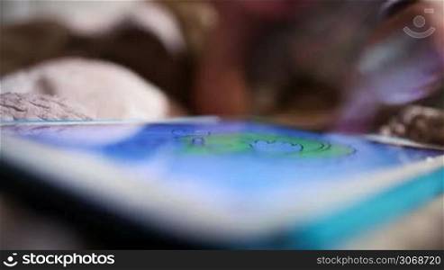 Little boy colouring picture on touchpad screen. Boy&acute;s hand and tablet in the foreground
