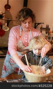 Little boy cooking with his mother