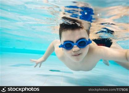 Little boy diving in the swimming pool. Leisure activities. Aquapark.. Little boy diving in the swimming pool.