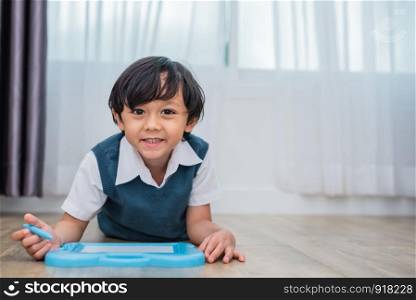Little boy drawing cartoon in chalkboard in home. Education and Back to school concept. Kids development theme.