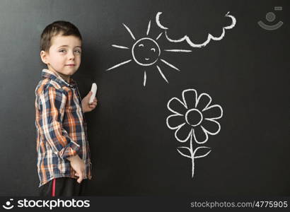 Little boy drawing on the blackboard