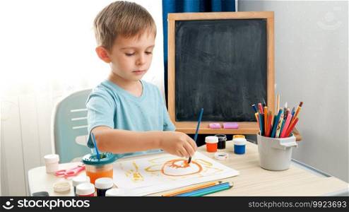 Little boy drawing picture in school classroom. Creative child doing art painting. Education at home during lockdown.. Little boy drawing picture in school classroom. Creative child doing art painting. Education at home during lockdown