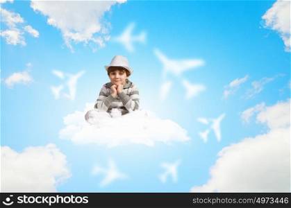 Little boy dreaming. Image of little boy sitting on clouds and relaxing