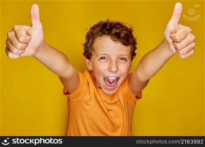 Little boy full of joy and energy under the light of a bright studio under the color yellow