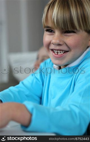 Little boy giggling in class