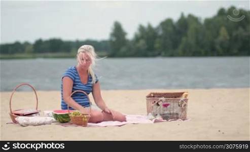 Little boy giving flower to his mom at the beach on summer vacation. Family spending time together on picnic