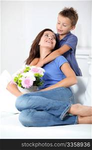 Little boy giving flowers to his mom on mother&acute;s day