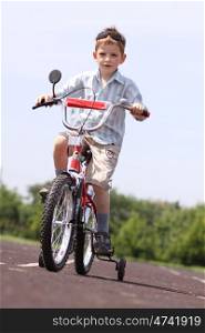 little boy goes for a drive on a bicycle