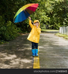 little boy holding umbrella his head