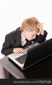 Little boy in a business suit with the laptop in the confusion, isolated