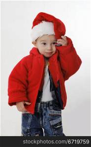 Little boy in a Santa Claus hat on the white background