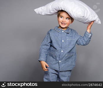 Little boy in blue pyjamas with pillow