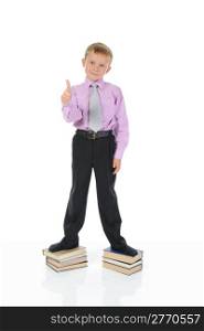 little boy in full growth standing on a pile of books. Isolated on white background