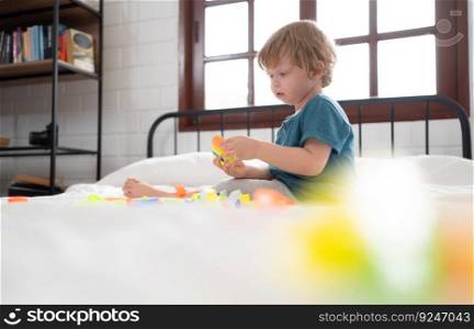 Little boy in his bedroom with a new toy purchased by his parents to help him improve his thinking skills.