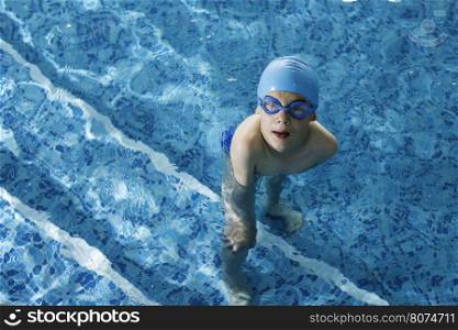 Little boy in swimming pool. Blue swimming pool.
