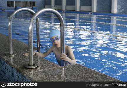 Little boy in swimming pool. Blue swimming pool.