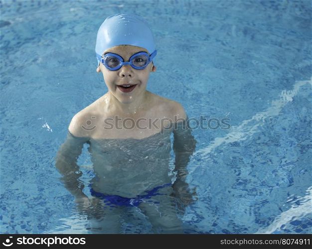 Little boy in swimming pool. Blue swimming pool.