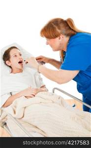 Little boy in the hospital opening his mouth so a nurse can examine his throat. Isolated on white.