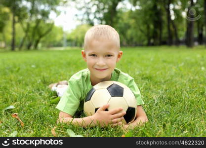 Little boy in the summer park with a ball