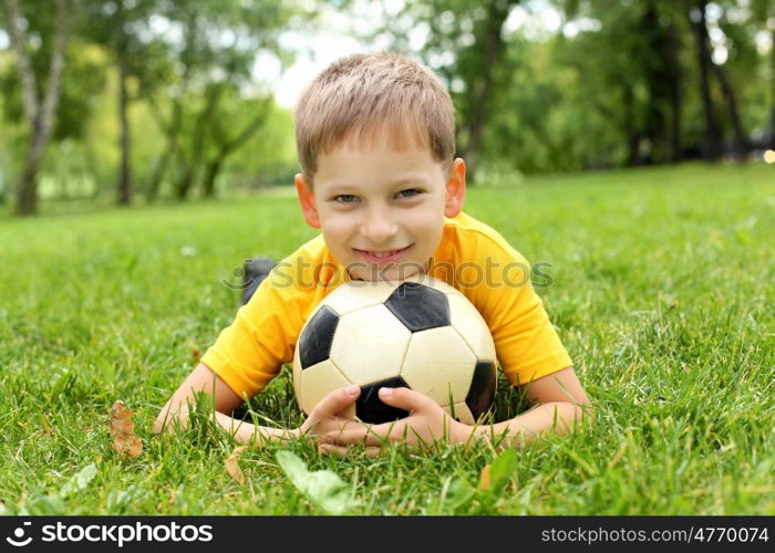 Little boy in the summer park with a ball