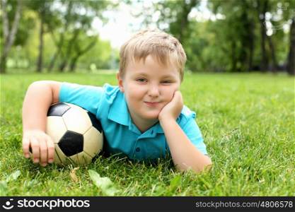 Little boy in the summer park with a ball