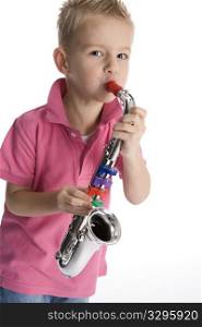 Little boy is playing a toy saxophone on white background