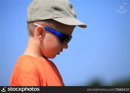 Little boy kid with sunglasses and cap outdoor sky background