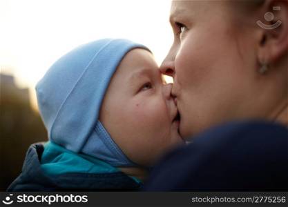 Little boy kissing his mom. Natural light, real colors, shallow DOF (prime 35mm L lense).