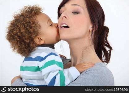 Little boy kissing mother