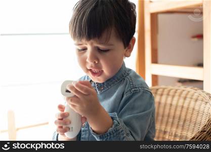 Little boy learning how to use a digital thermometer - Corona Virus 2020