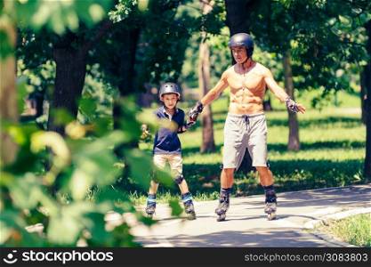 Little boy learning roller skating in park with his grandfather