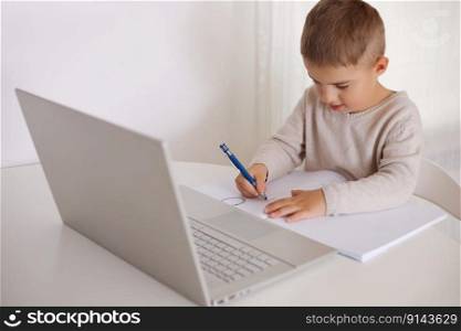 Little boy learning with a laptop at home. Online education and e-learning concept. Home quarantine distance learning. Modern kid and education technology. Little boy learning with a laptop at home. Online education and e-learning concept. Home quarantine distance learning. Modern kid and education technology.