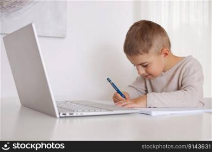 Little boy learning with a laptop at home. Online education and e-learning concept. Home quarantine distance learning. Modern kid and education technology. Little boy learning with a laptop at home. Online education and e-learning concept. Home quarantine distance learning. Modern kid and education technology.