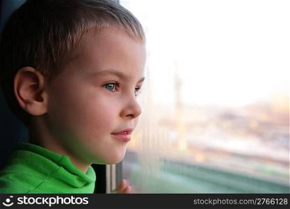 little boy looks in train`s window