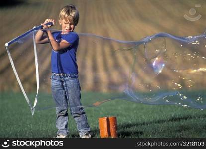 Little Boy Making a Huge Bubble