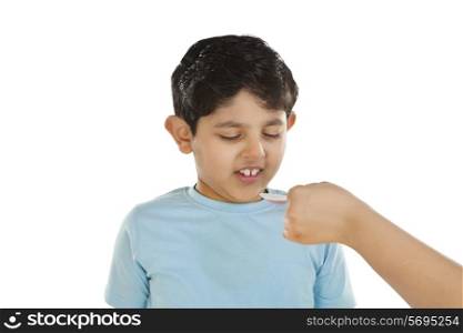 Little boy making face while having medicine